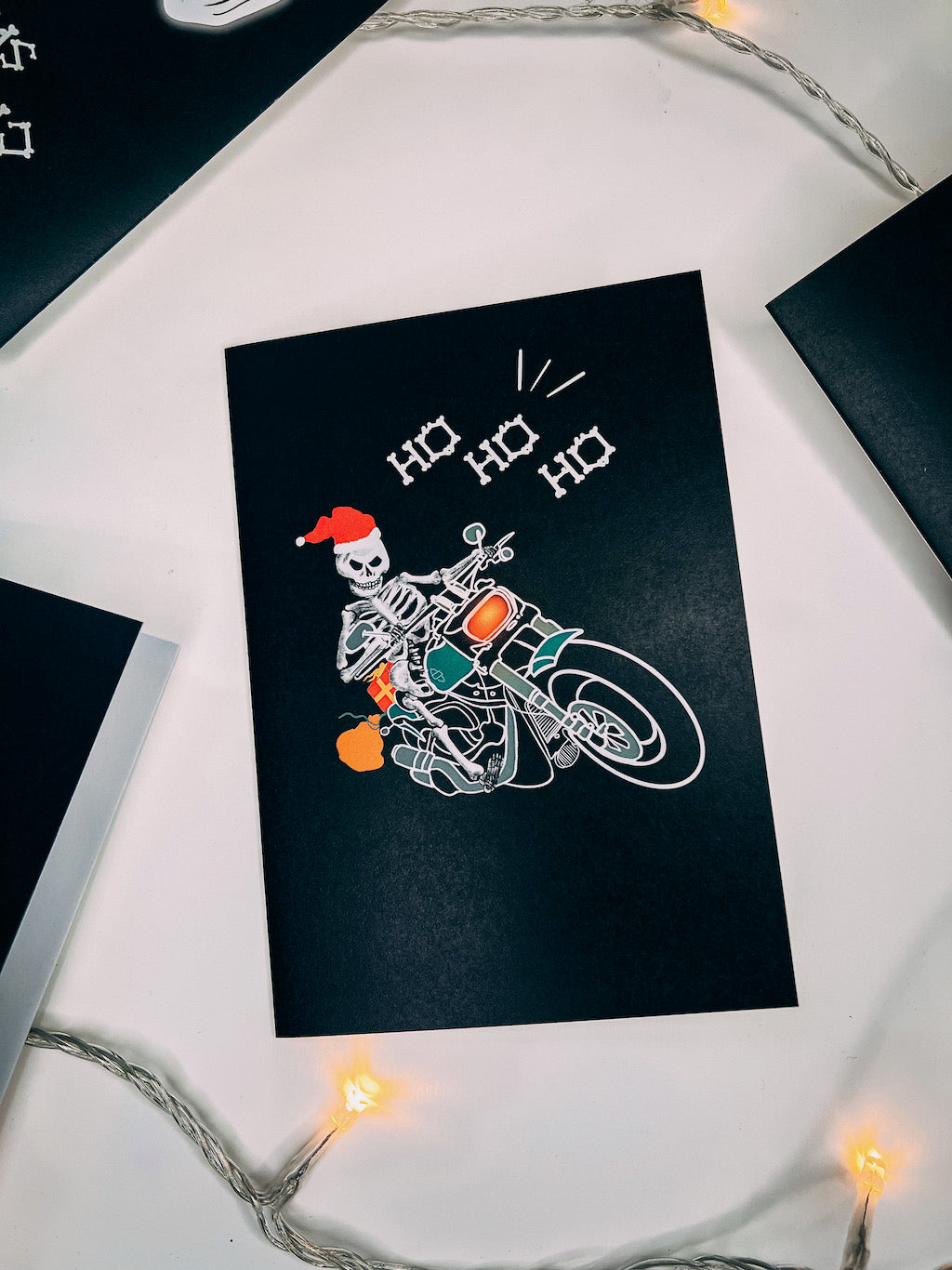 Wayward black greetings card with Biker Skeleton Santa Claus on a motorbike with bone lettering saying Ho Ho Ho
