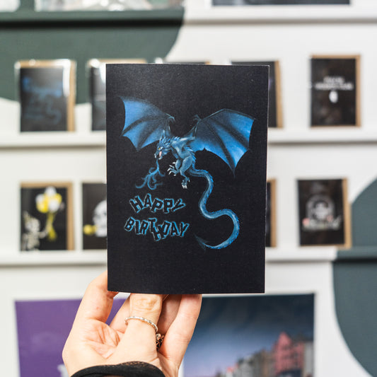 A Birthday Card Featuring A blue dragon on a black background by Wayward