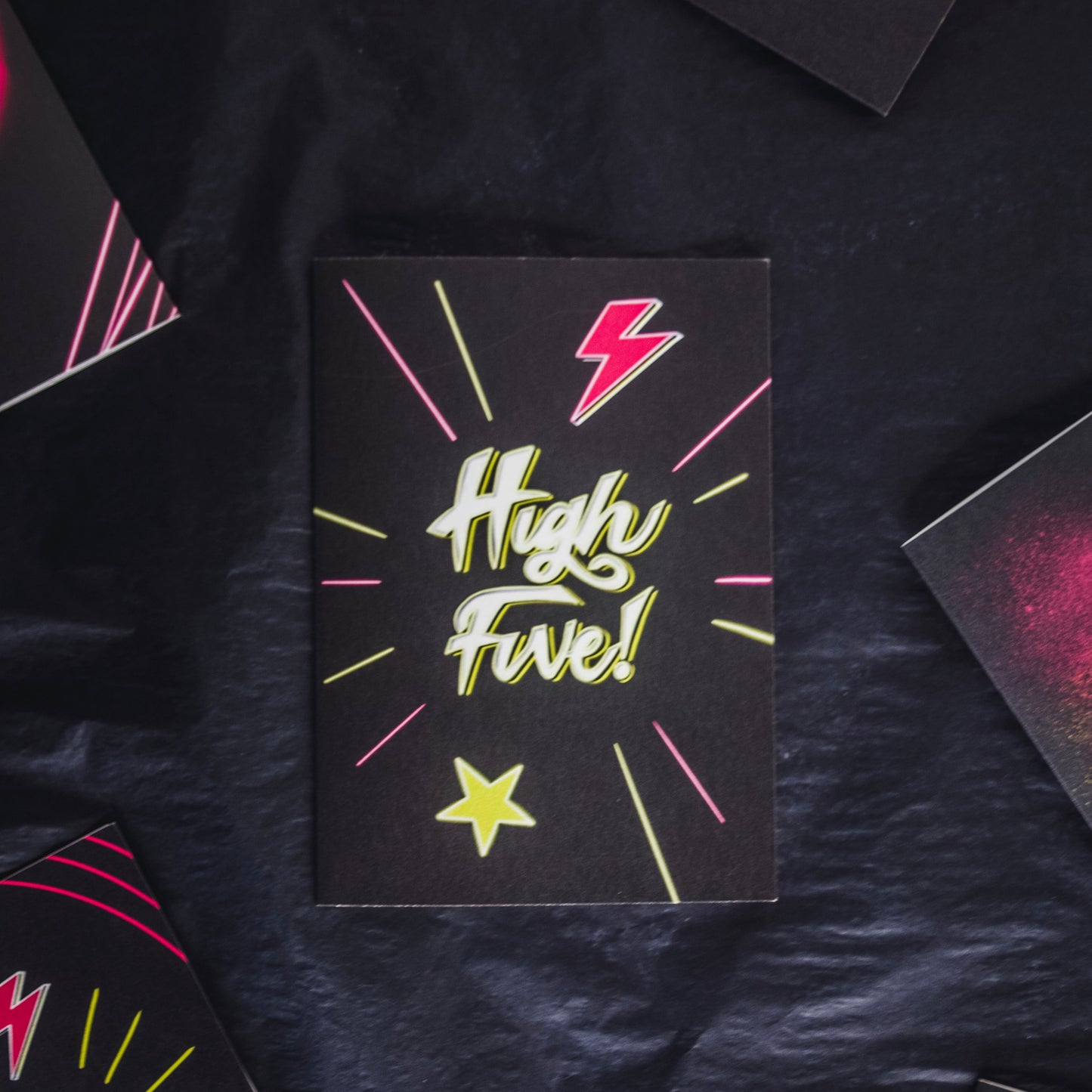 Black Greetings Card With White and Yellow Neon High Five Writing with Lightening Bolt and Star Design by Wayward