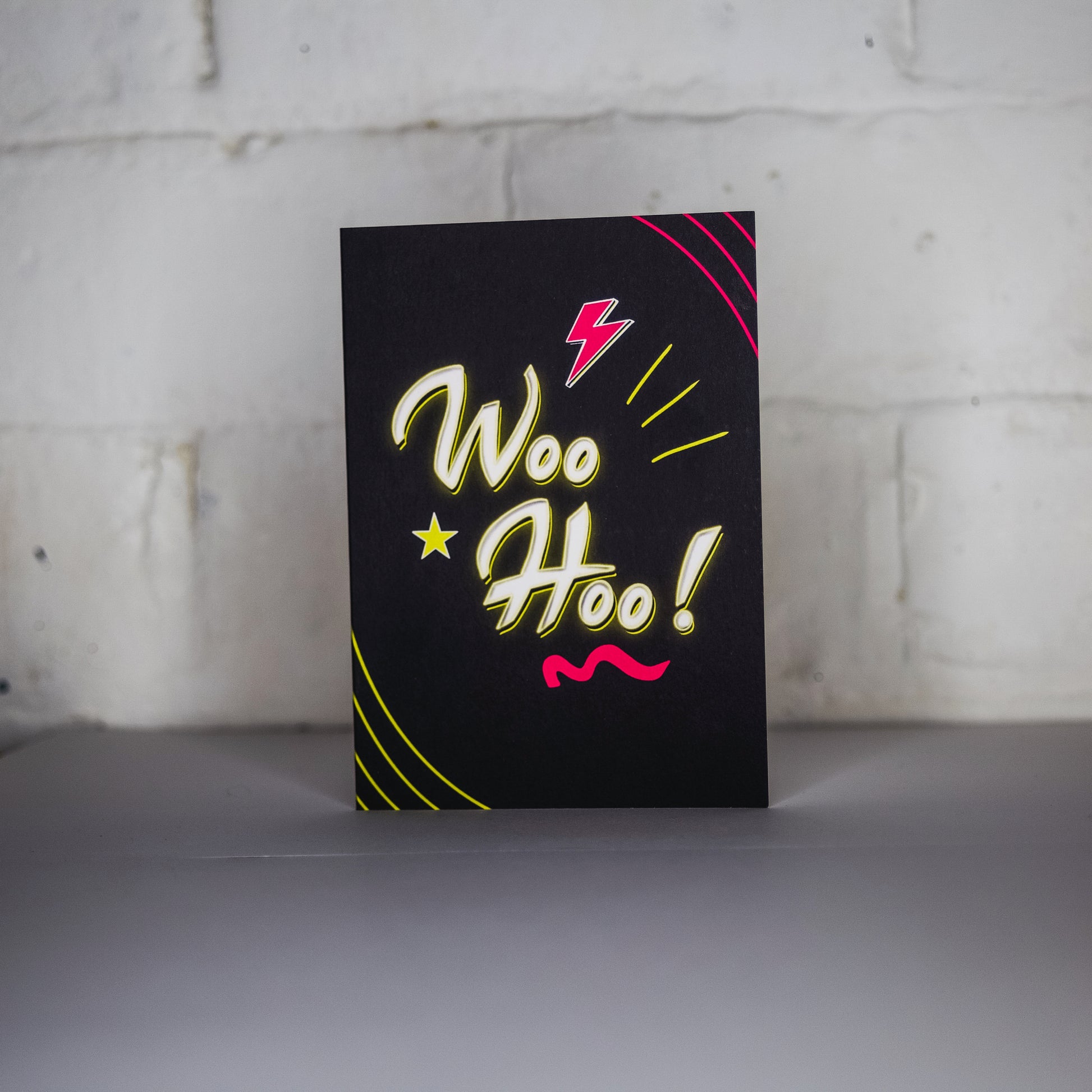 Black Greetings Card With WOO HOO written in white and yellow neon writing by wayward