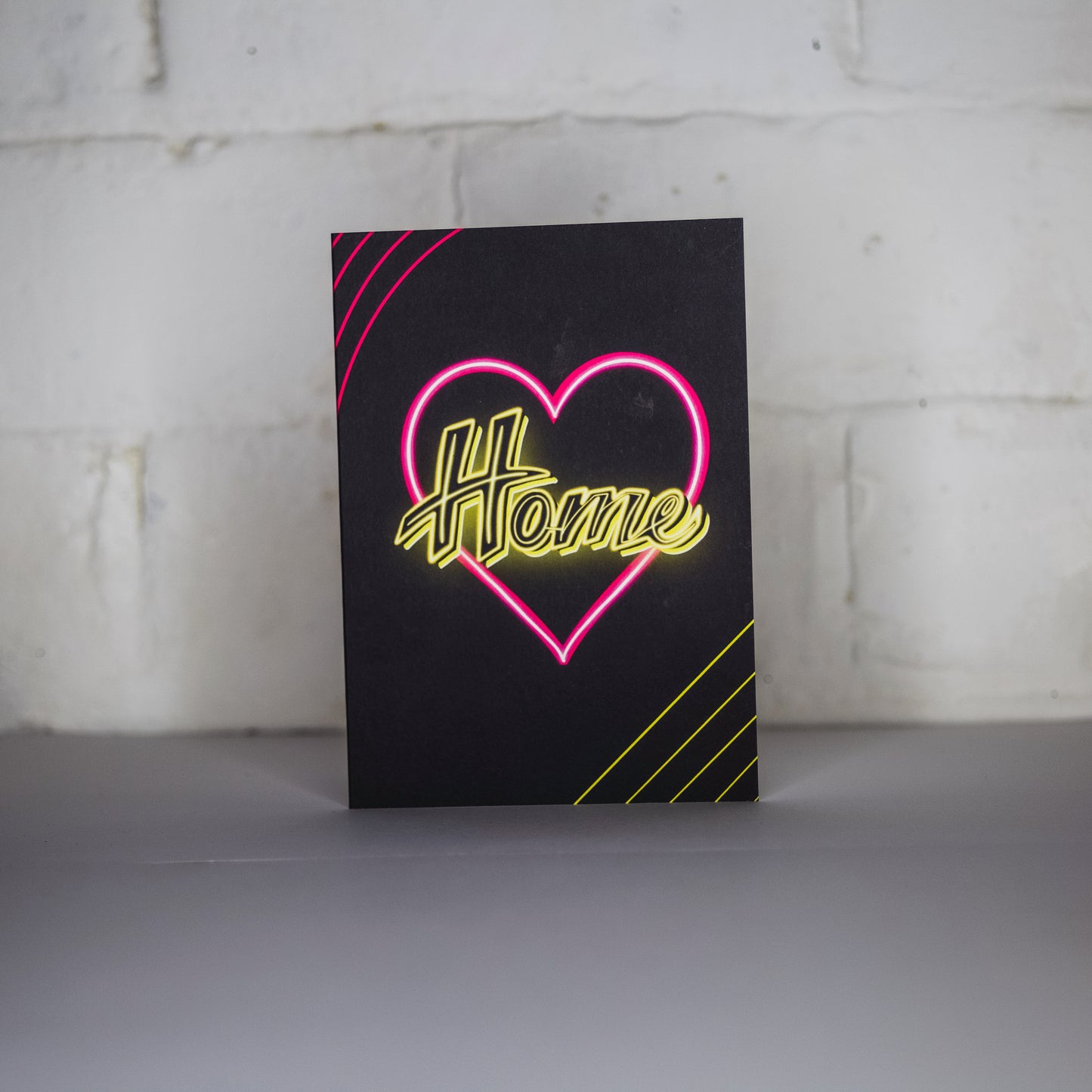 Black Greetings Card With Yellow Home Written in Pink Neon Heart by Wayward