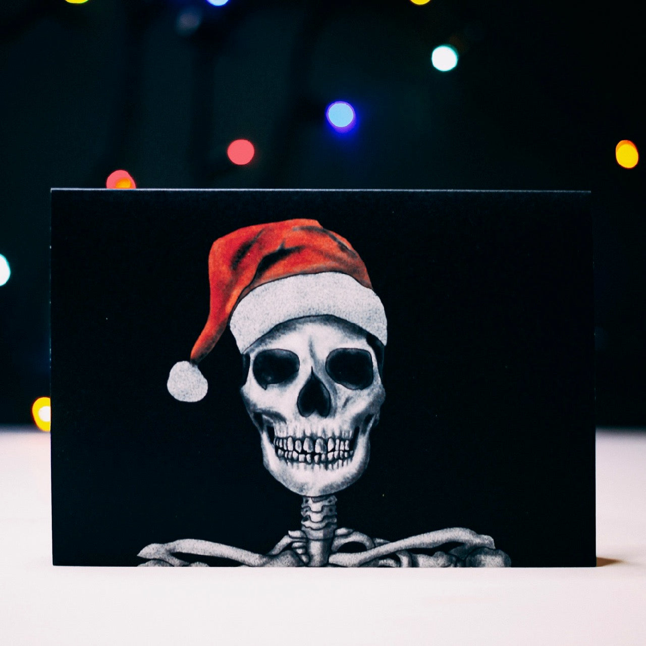 Skull with santa hat on black background christmas card by wayward