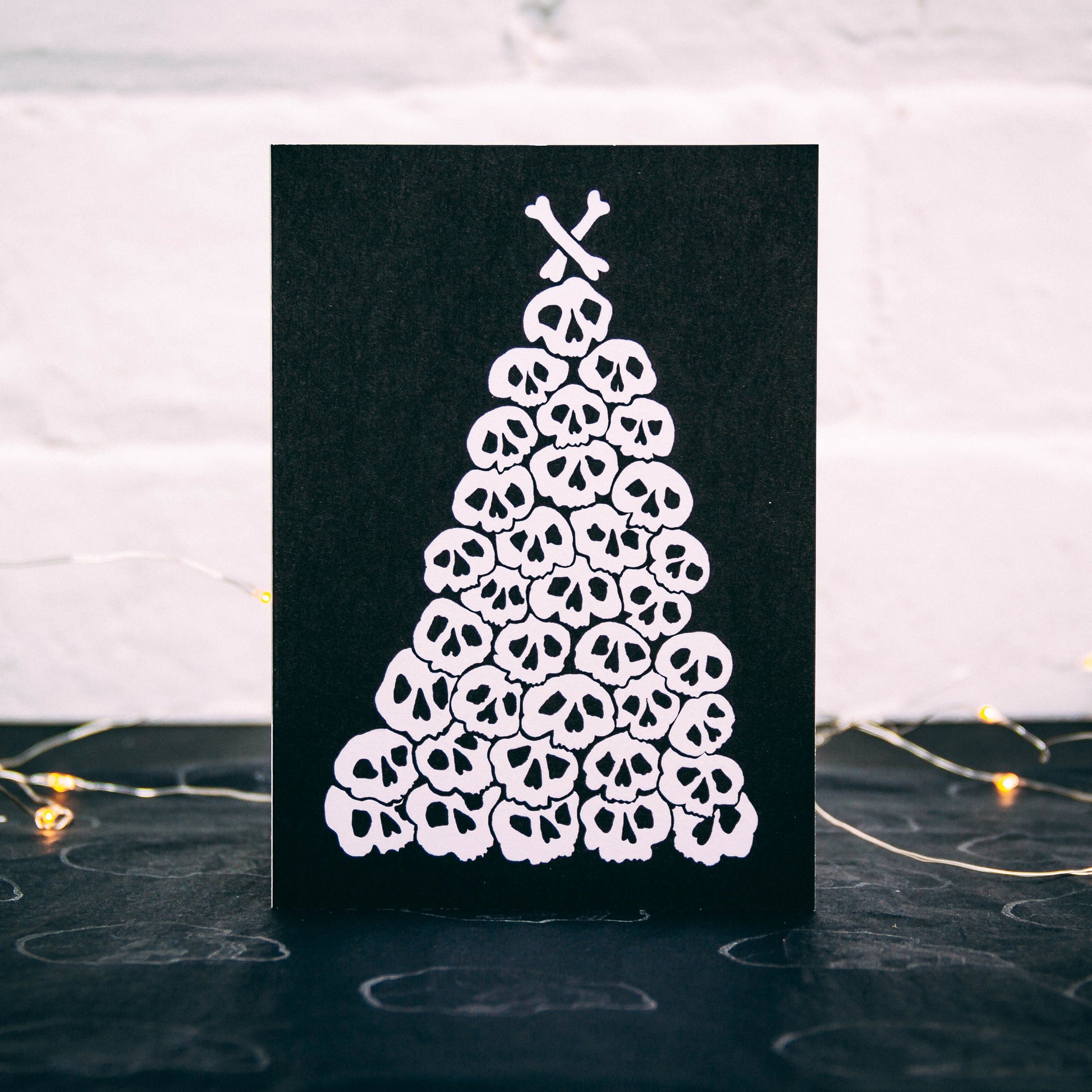 Christmas tree made of pile of illustrated skulls on black background. Christmas Card by wayward