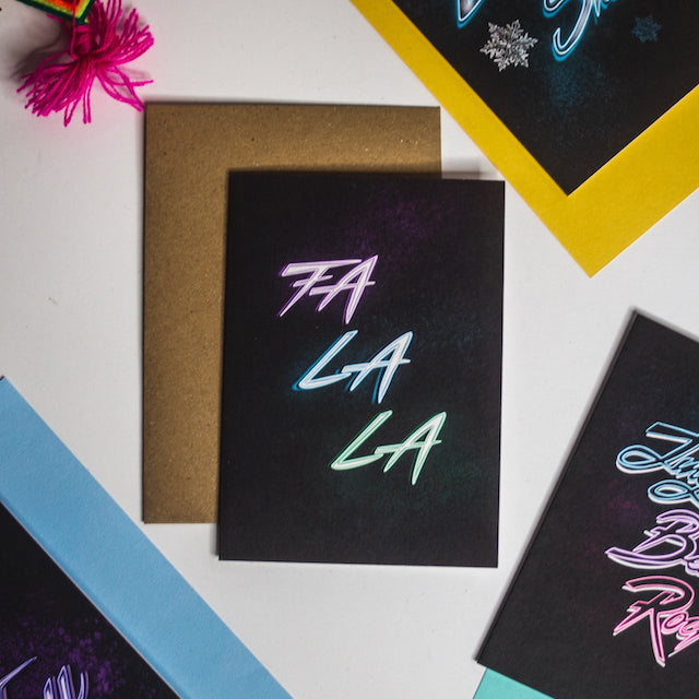 Fa La La neon writing on black background christmas card by wayward
