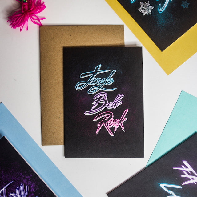 Jingle bell rock neon writing on black background christmas card by wayward