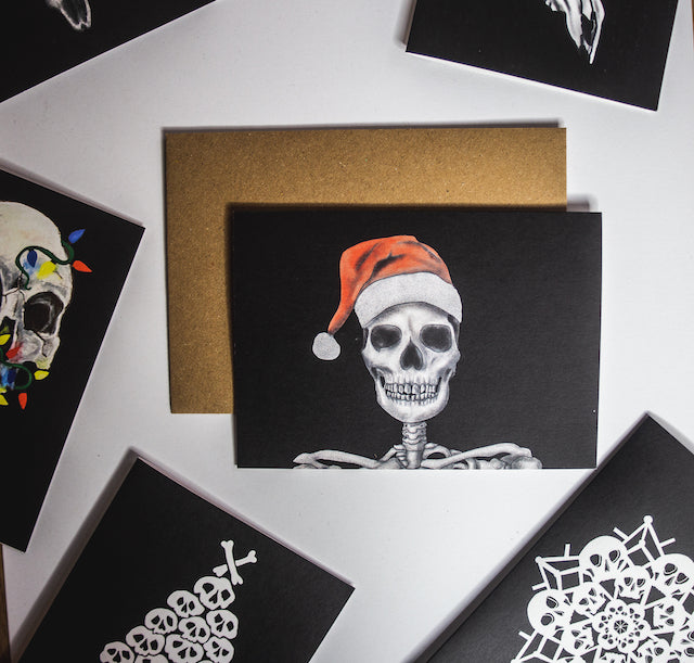 Skull with santa hat on black background christmas card by wayward