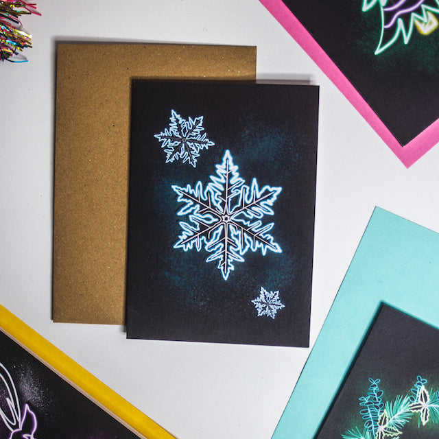 Blue neon snowflake on black background christmas card by Wayward