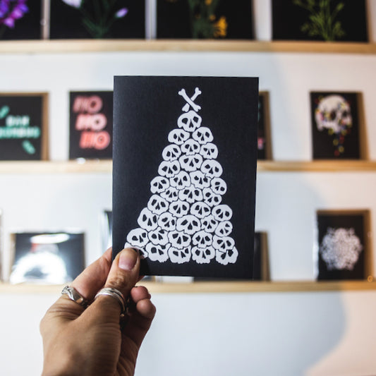 Christmas tree made of pile of illustrated skulls on black background. Christmas Card by wayward