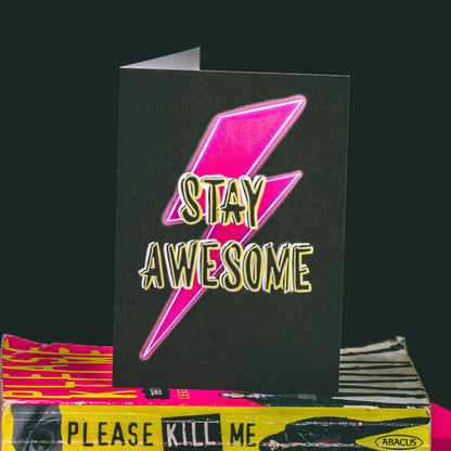 A6 Black Greetings Card With Pink Bowie Lightening Bolt and Stay Awesome Slogan by  Wayward 