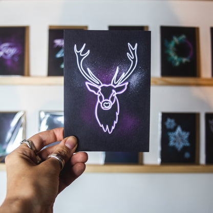 Purple neon stag on black background christmas card by wayward