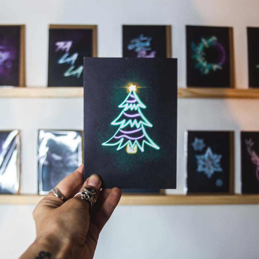 Christmas card by Wayward. Green neon tree on black background