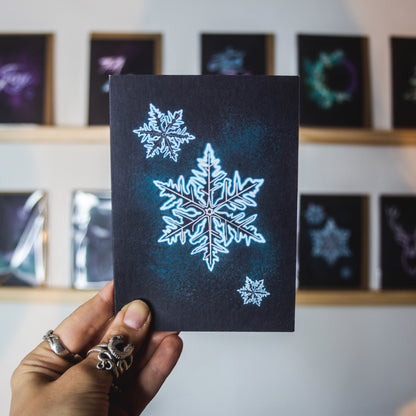 Blue neon snowflake on black background christmas card by Wayward 