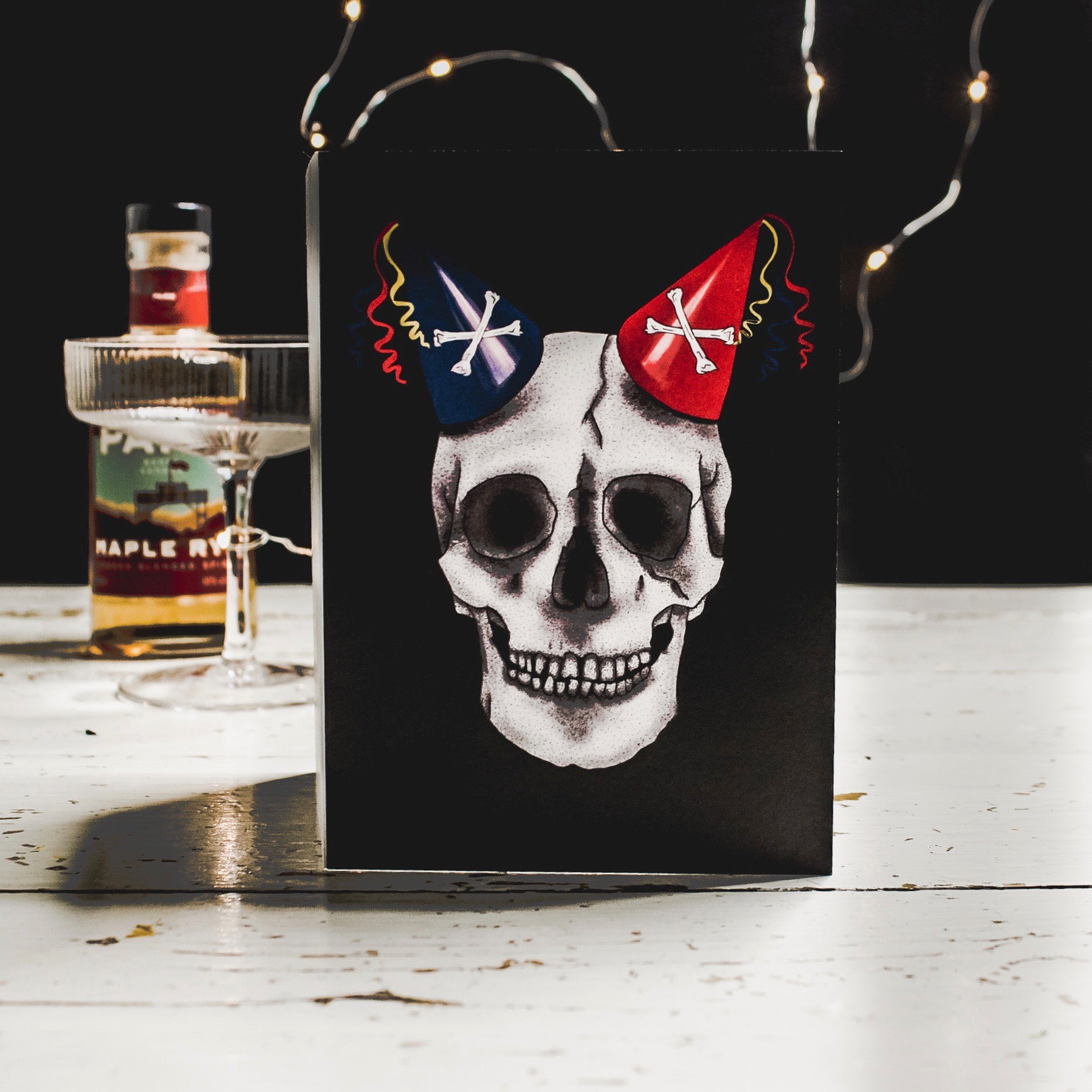Black Birthday Card with Illustration of skull wearing party hats as horns 