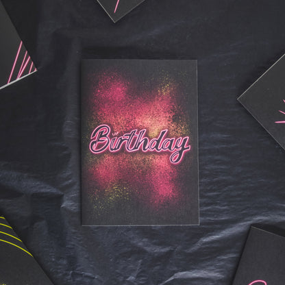Greetings card with pink neon birthday on pink and yellow paint splatter by wayward