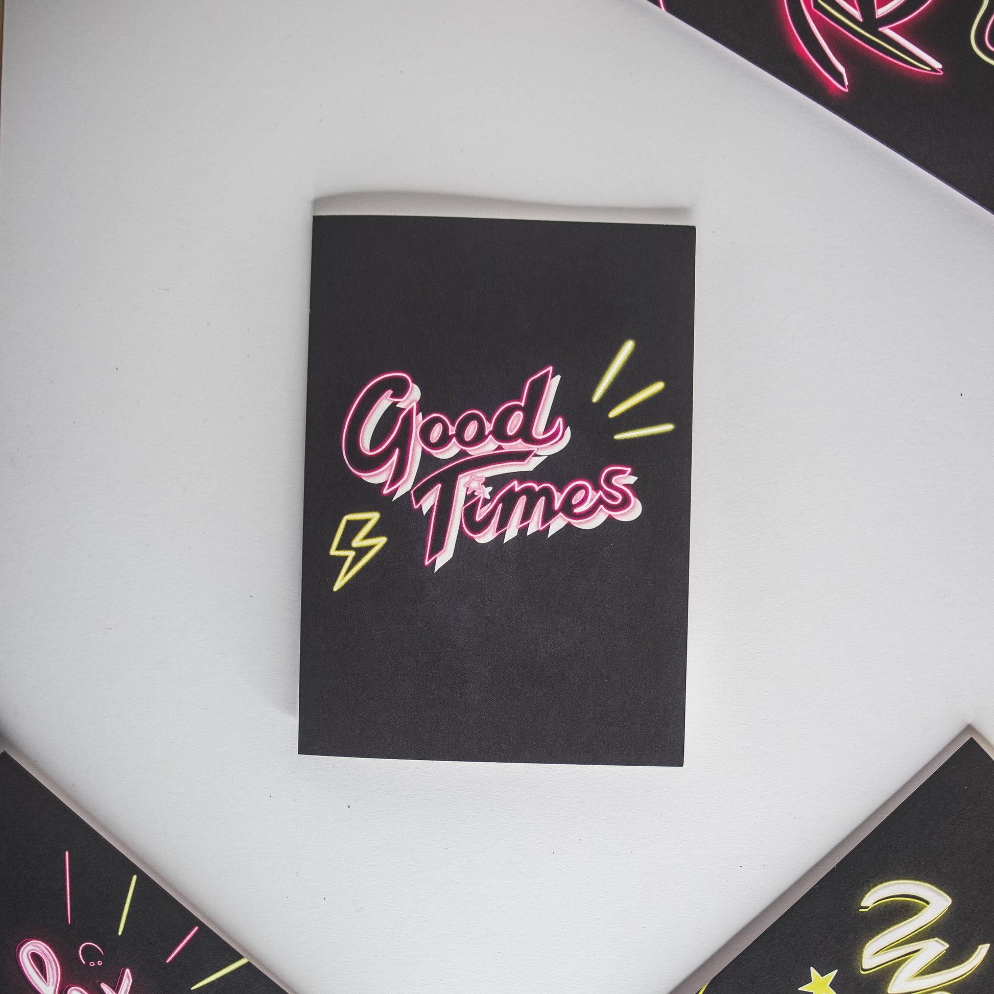 Greetings card with black background and pink Good Times neon writing by Wayward