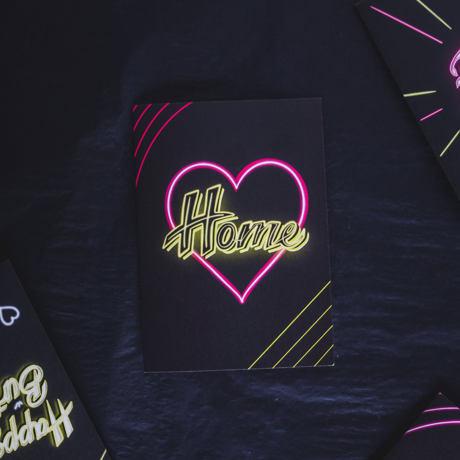 Black Greetings Card With Yellow Home Written in Pink Neon Heart by Wayward