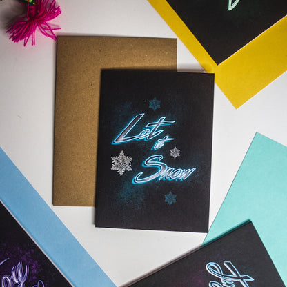 Let is snow neon writing in blue on black background christmas card by wayward