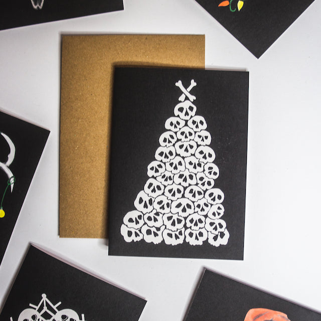 Christmas tree made of pile of illustrated skulls on black background. Christmas Card by wayward